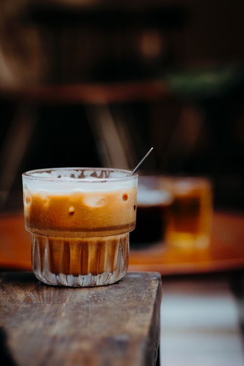 Free An artistic close-up of a refreshing iced coffee on a rustic wooden table. Stock Photo