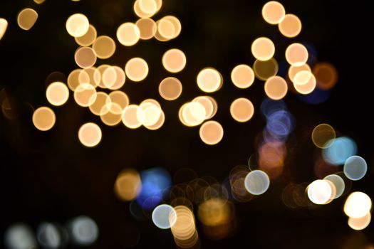 A vibrant display of abstract bokeh lights against a dark background, creating a warm and festive ambiance.
