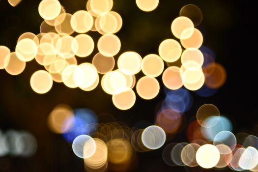 Bokeh image of warm glowing lights with artistic blurring, creating a festive ambiance.