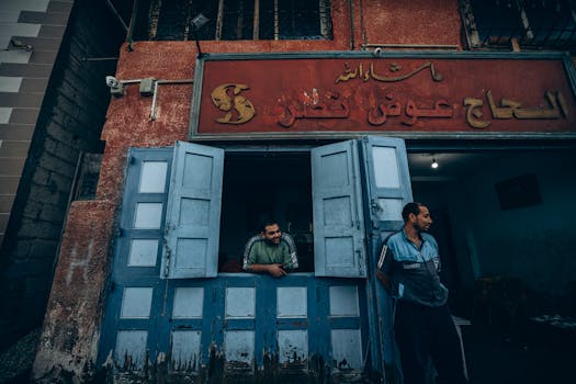 Two men at a vibrant shopfront in Damietta, Egypt, capturing local culture.