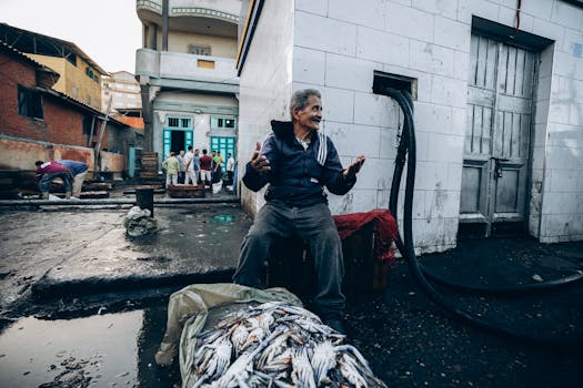 A candid scene depicting a fisherman at a bustling fish market in Damietta, Egypt.