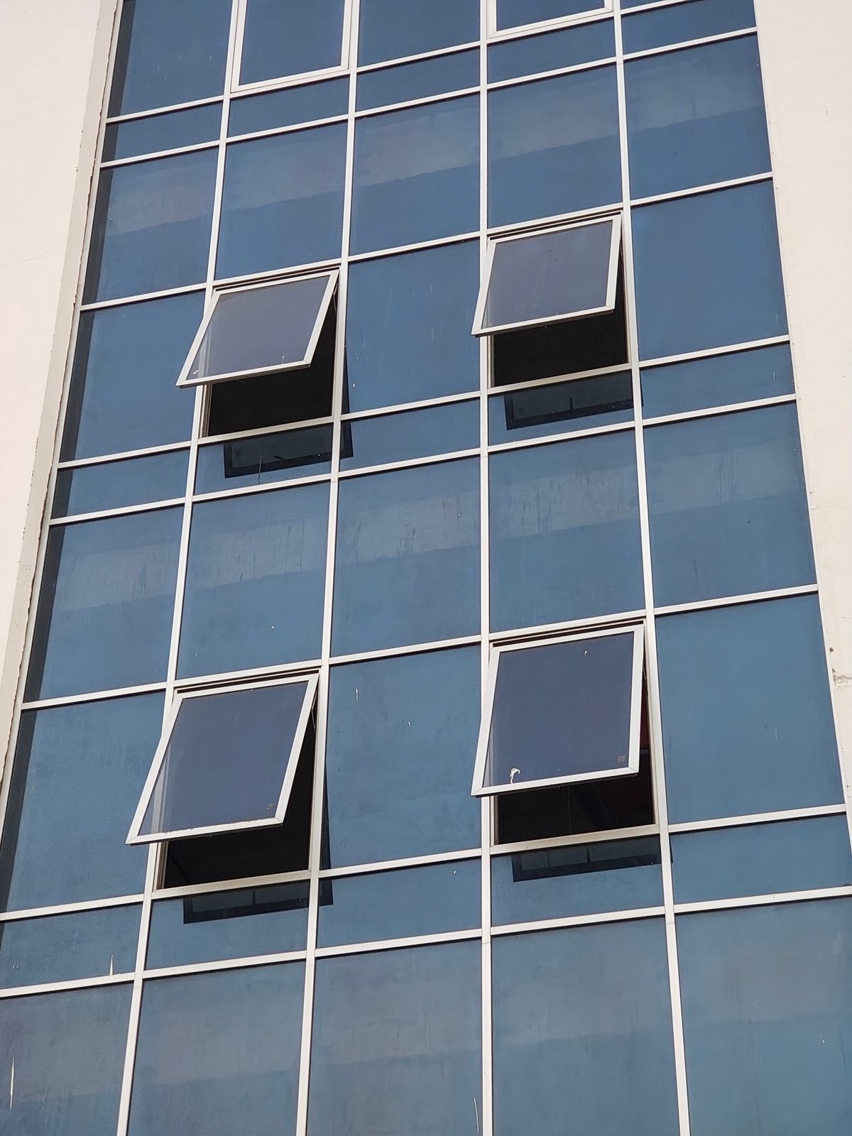 Modern blue glass building facade showing premium architectural glass installation