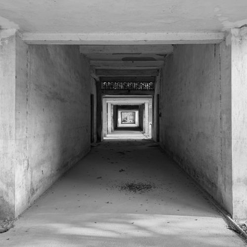 Free Black and white photo showing an endless concrete corridor with dramatic perspective. Stock Photo