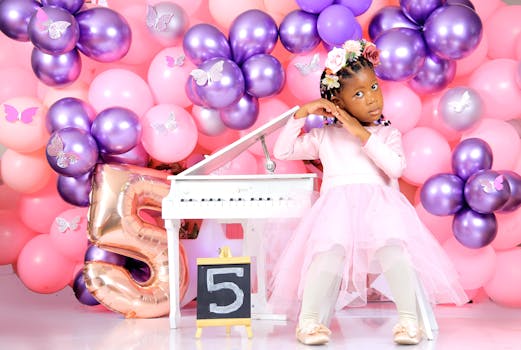 Girl in pink dress at a birthday party with colorful balloons and piano.