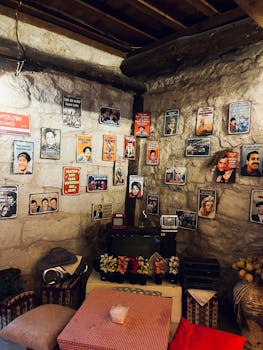 Cozy stone room decorated with vintage retro posters and quaint furnishings.