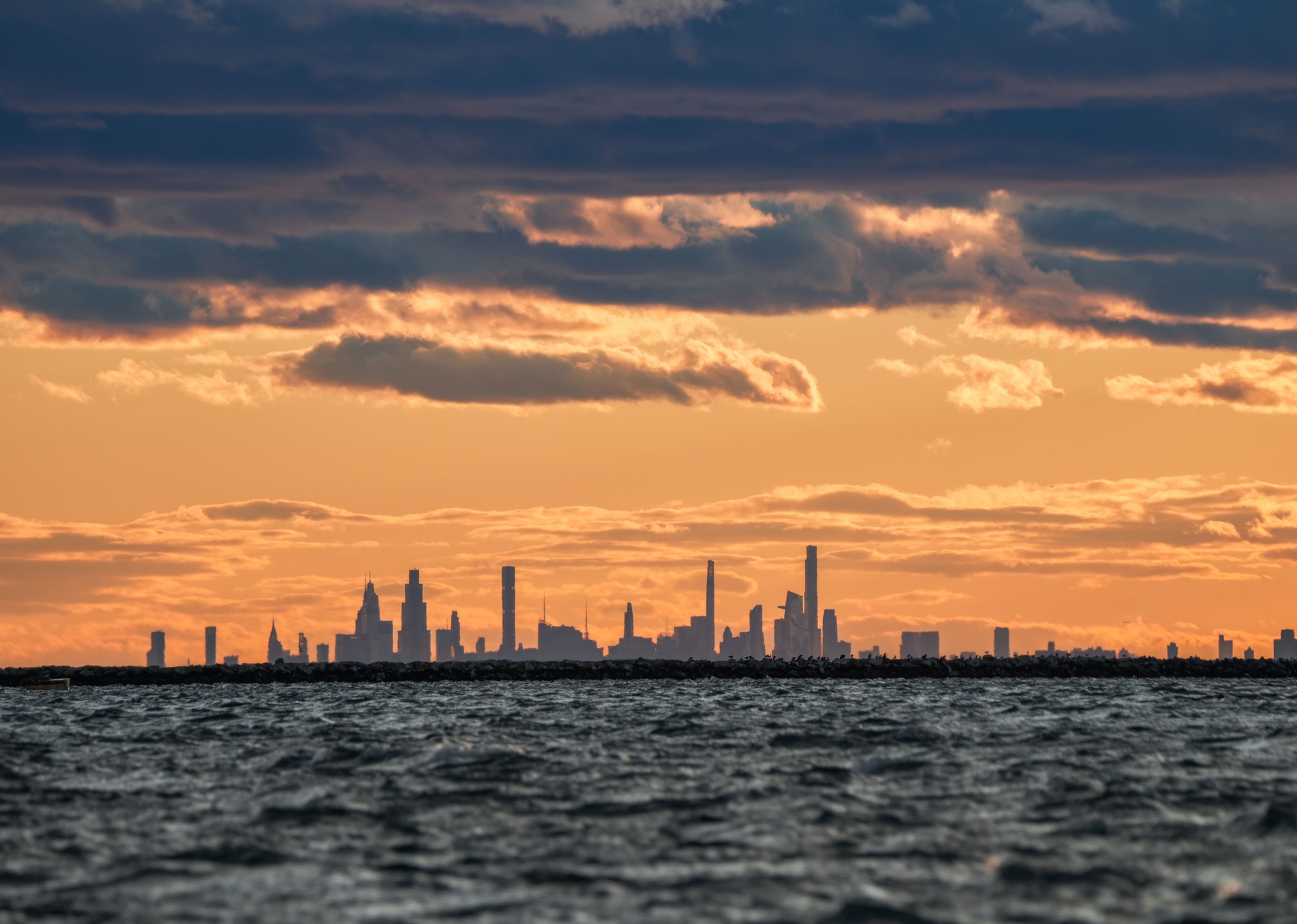 Dramatic City Skyline at Sunset Over Water · Free Stock Photo