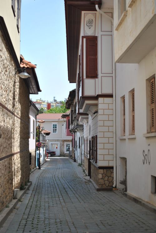 Free Charming narrow street with cobblestone path and traditional European houses in a peaceful village setting. Stock Photo