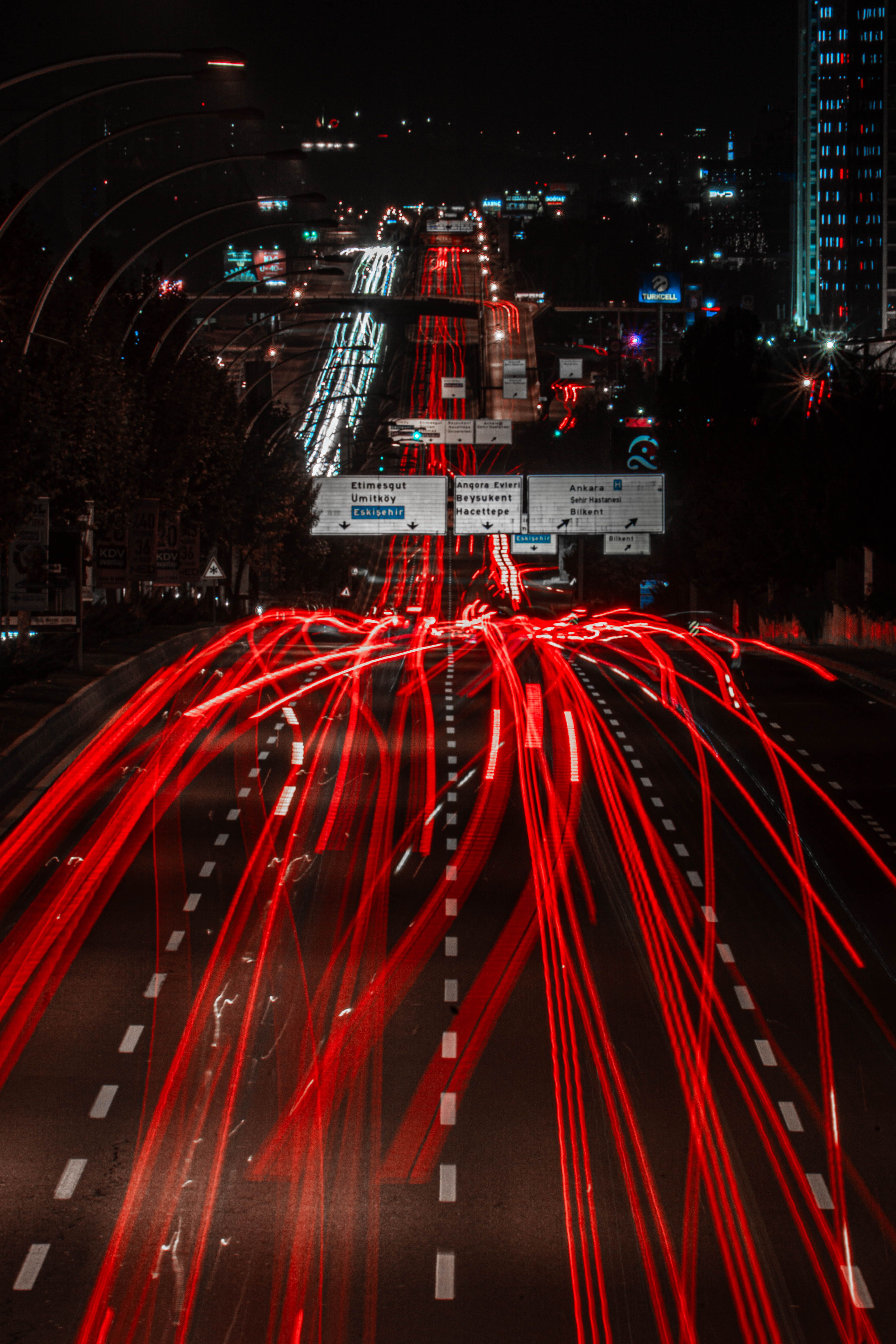Vibrant red light trails of city traffic speeding at night on a busy urban road.