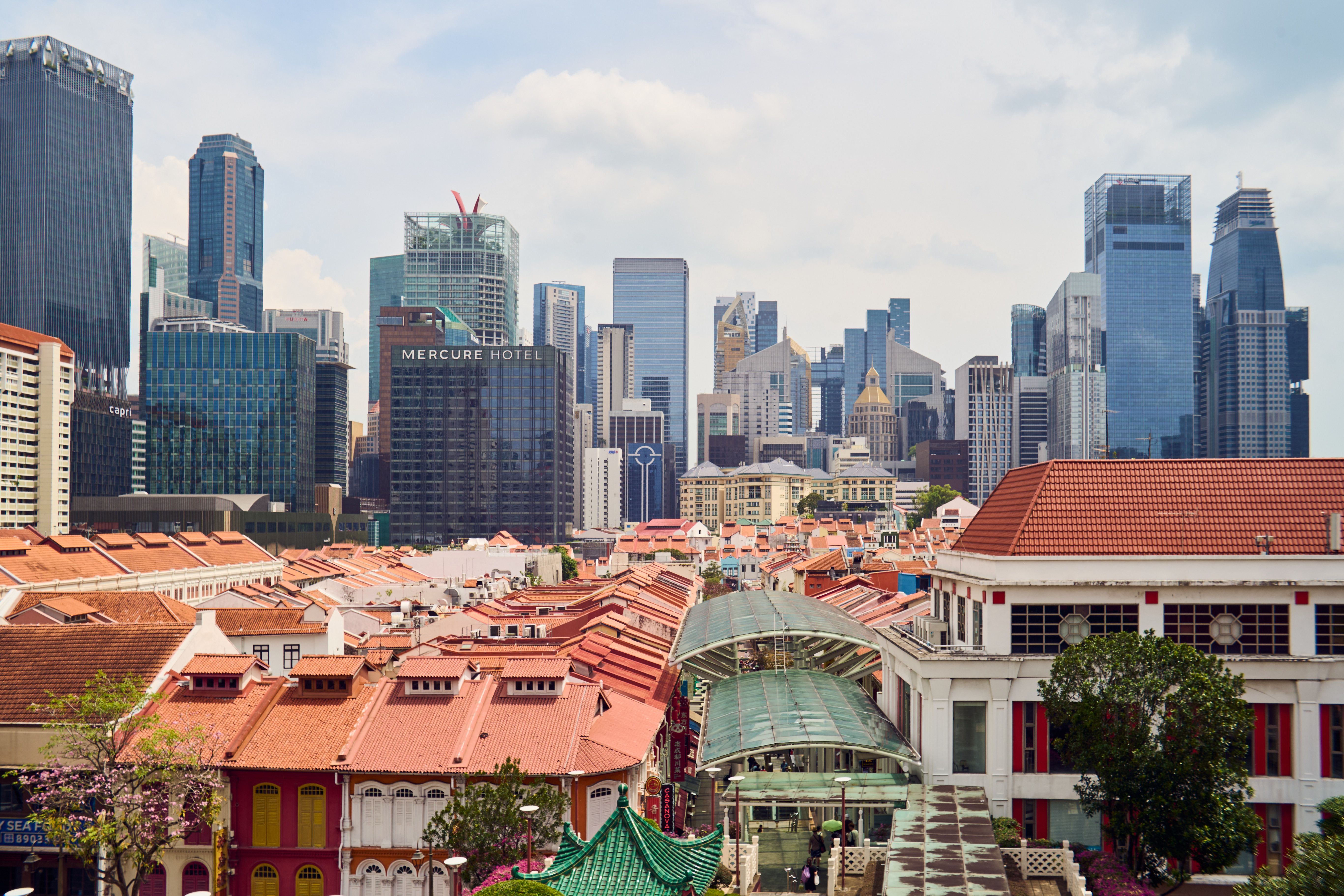 View of the vibrant Chinatown district in Singapore with modern skyscrapers in the background.