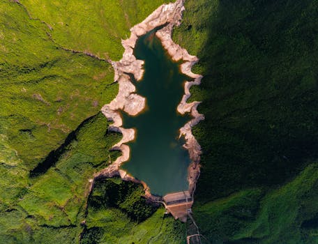 Spectacular aerial shot of a reservoir with rugged shores enveloped by verdant greenery.