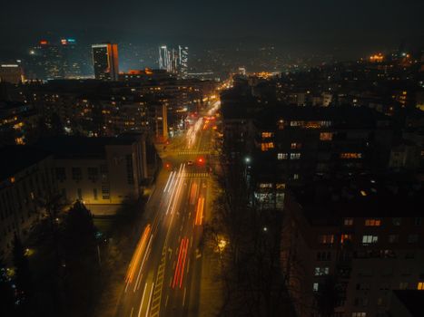A dynamic view of a bustling city at night, showcasing colorful light trails and illuminated streets.