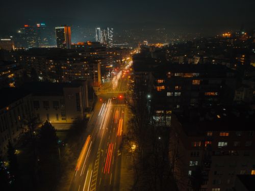 Free A dynamic view of a bustling city at night, showcasing colorful light trails and illuminated streets. Stock Photo