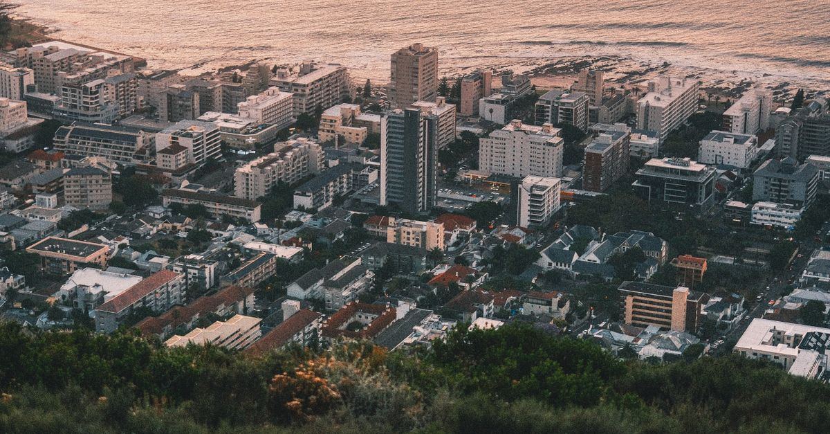 Aerial view of Cape Town, South Africa, showcasing the city and ocean at sunset.