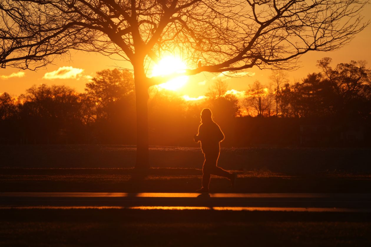 Silhouette of a runner jogging at sunset, representing the discipline mindset Eric Thomas teaches side hustlers