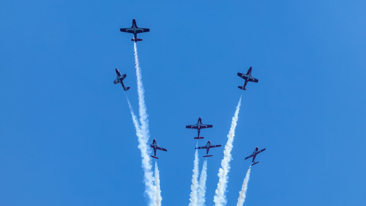 Jet aircraft performing airshow maneuvers — female Blue Angel pilots