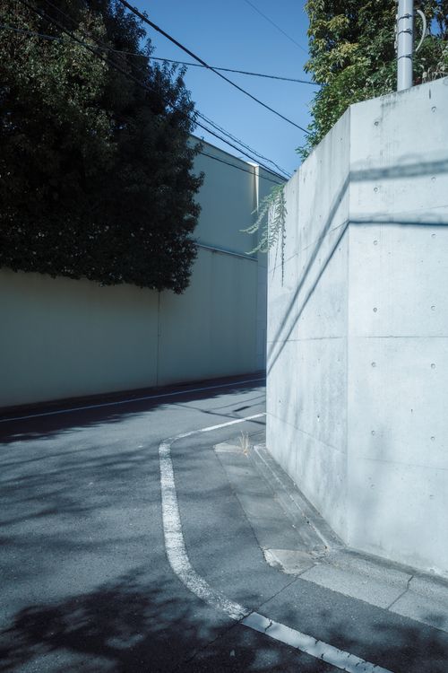 Free Peaceful street corner in Shibuya, Tokyo, showcasing modern urban design with concrete walls and shadows. Stock Photo
