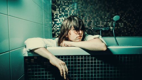 Free An artistic portrait of a person in a bathtub highlighting introspection and solitude. Stock Photo