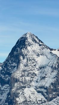 Stunning view of a snow-capped mountain in Lauterbrunnen, Switzerland under clear blue skies.