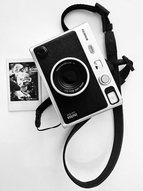 Free Black and white instant camera with a photo print on white background. Classic style. Stock Photo