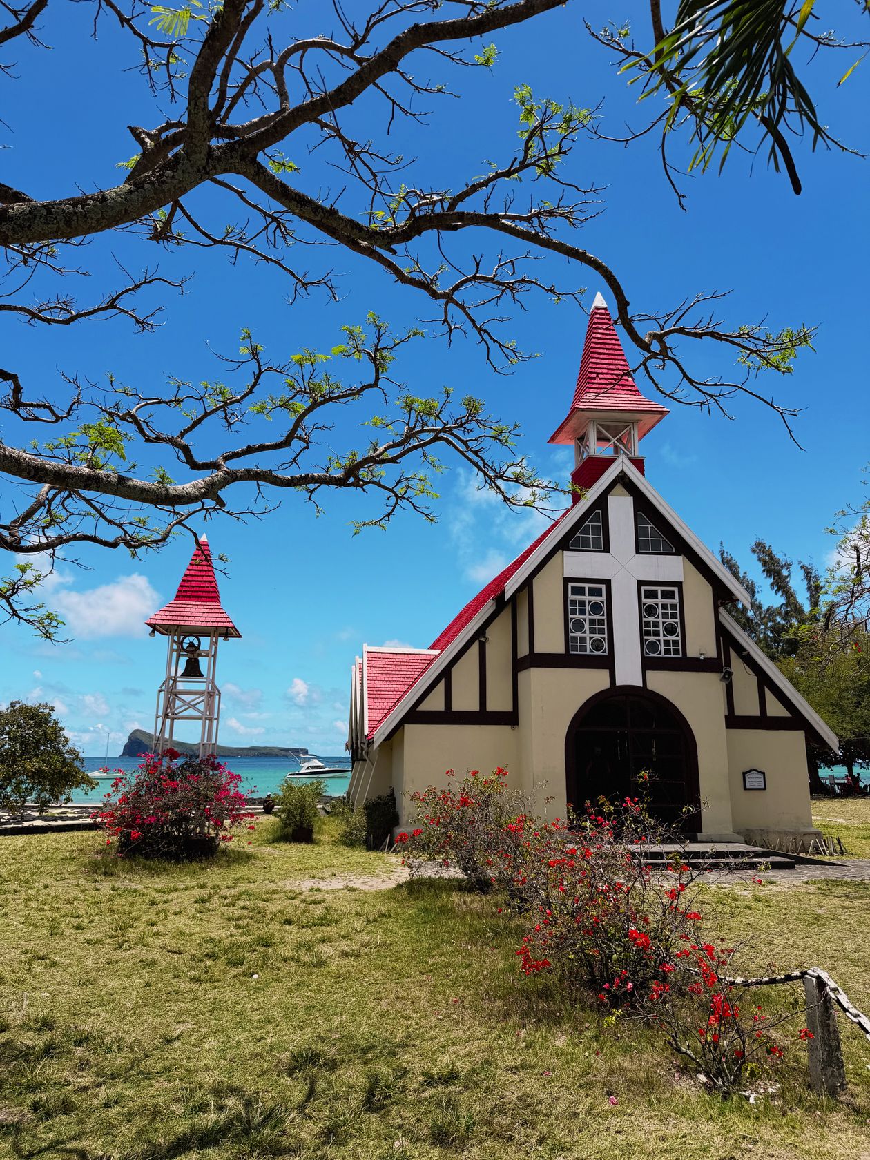 Cazare în Mauritius: biserica cu acoperiș roșu din Cap Malheureux, cu Coin de Mire în spate