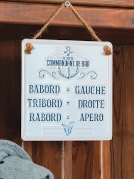 Rustic nautical-themed sign with French phrases for left, right, aperitif.