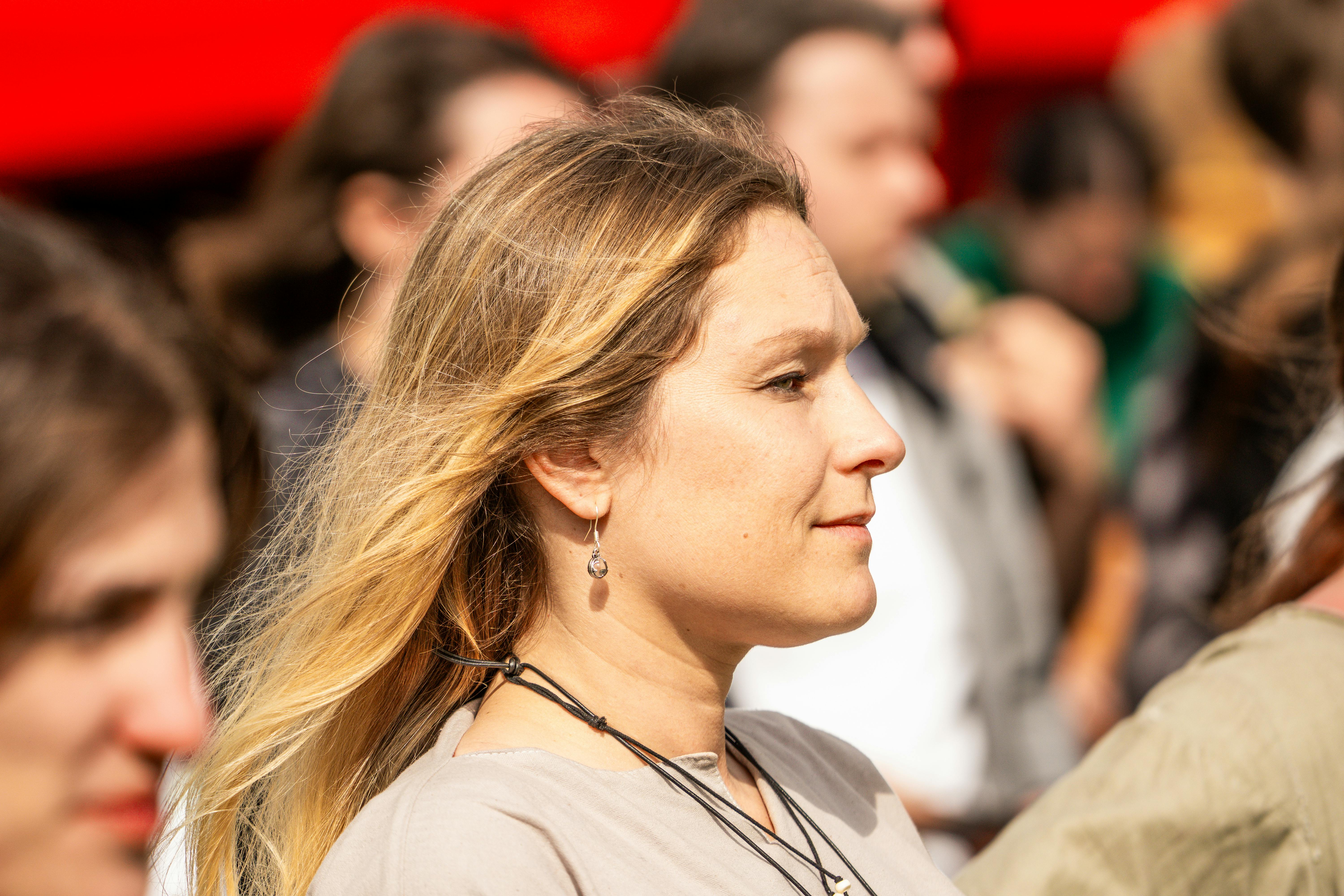 A woman enjoys an outdoor event in Szczecin, Poland. Sunlit with soft focus background.
