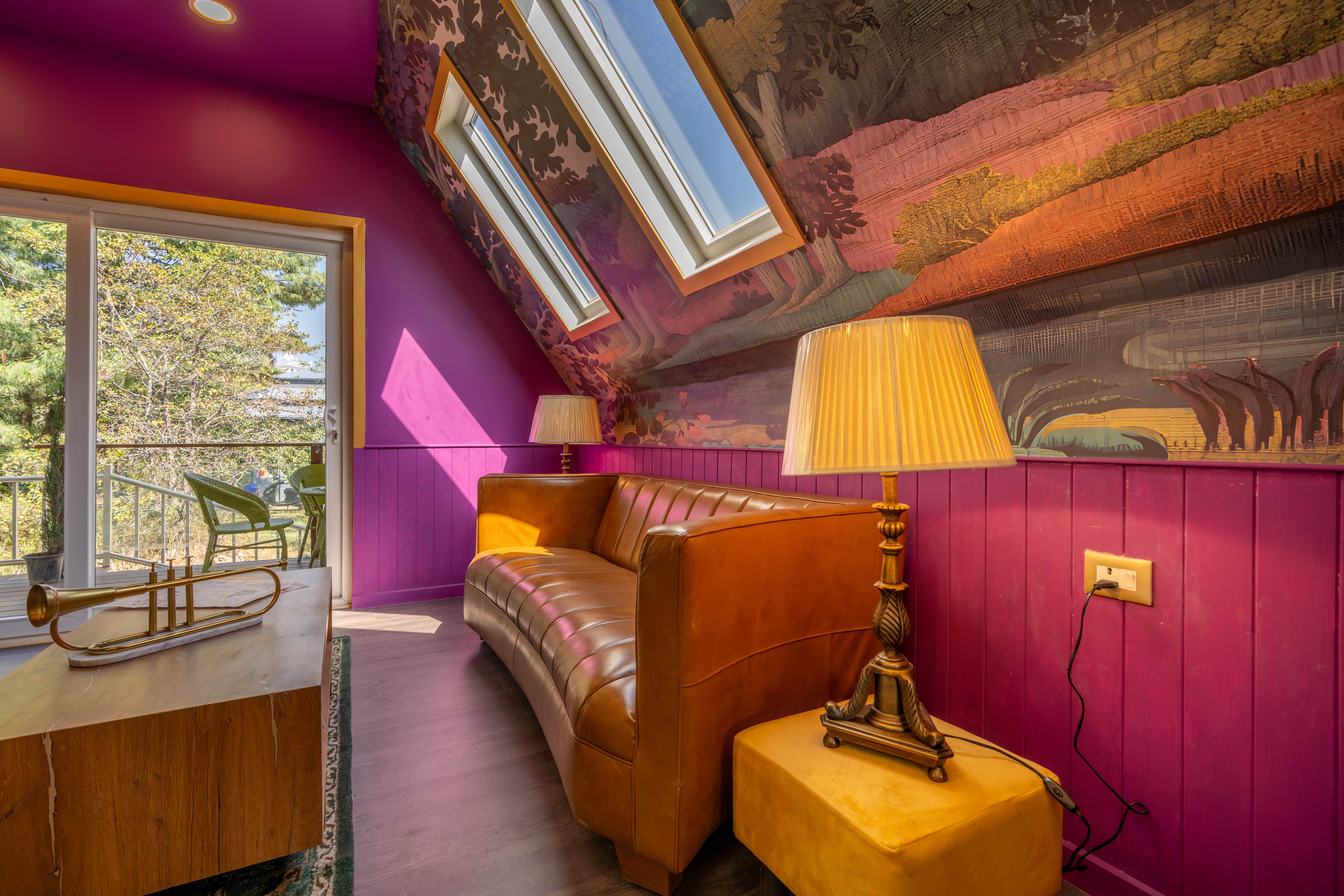 Heldere muurschildering met felle kleuren in woonkamer.