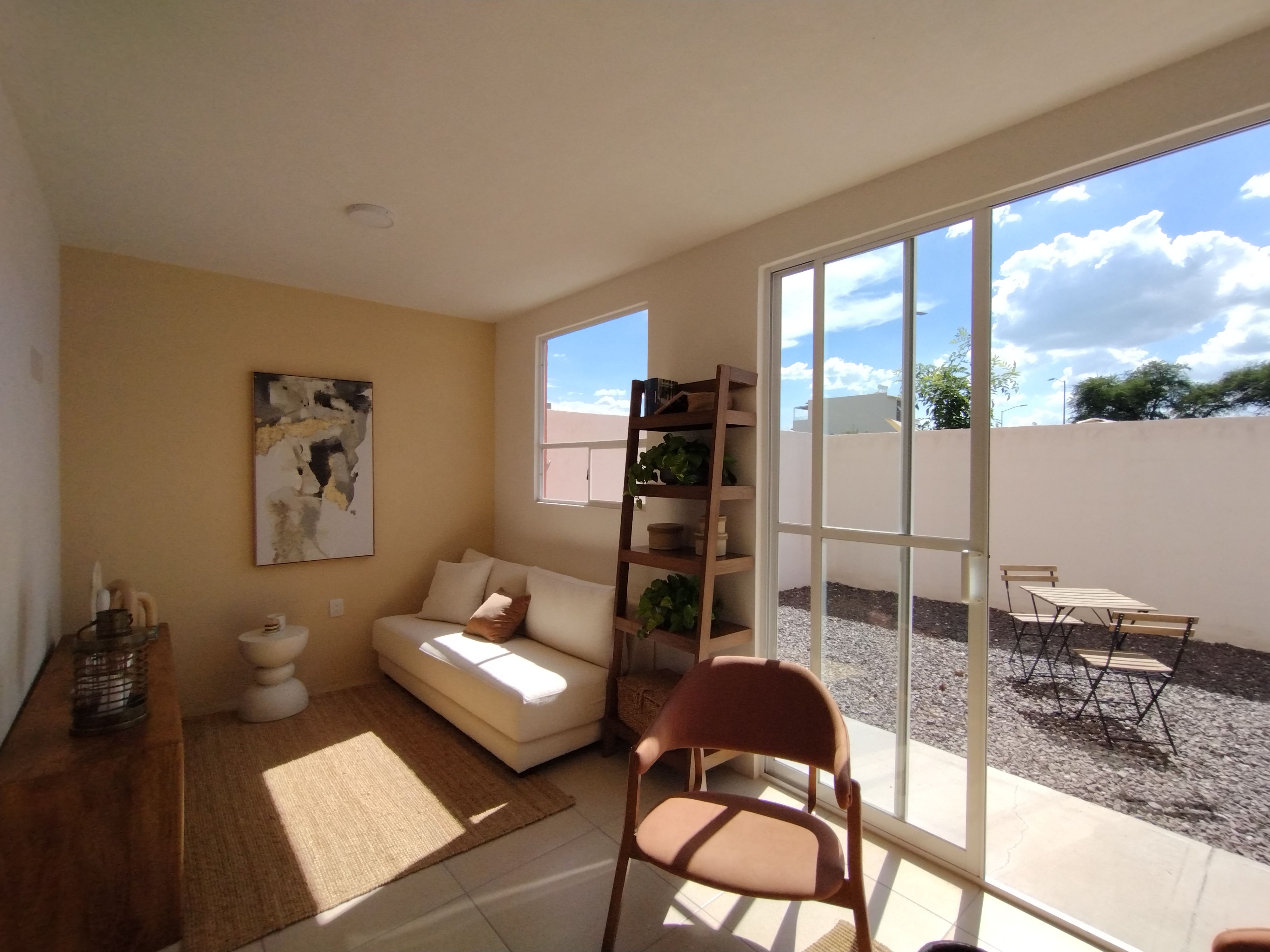 Spacious minimalist living room with natural light and outdoor patio access, creating a serene environment.
