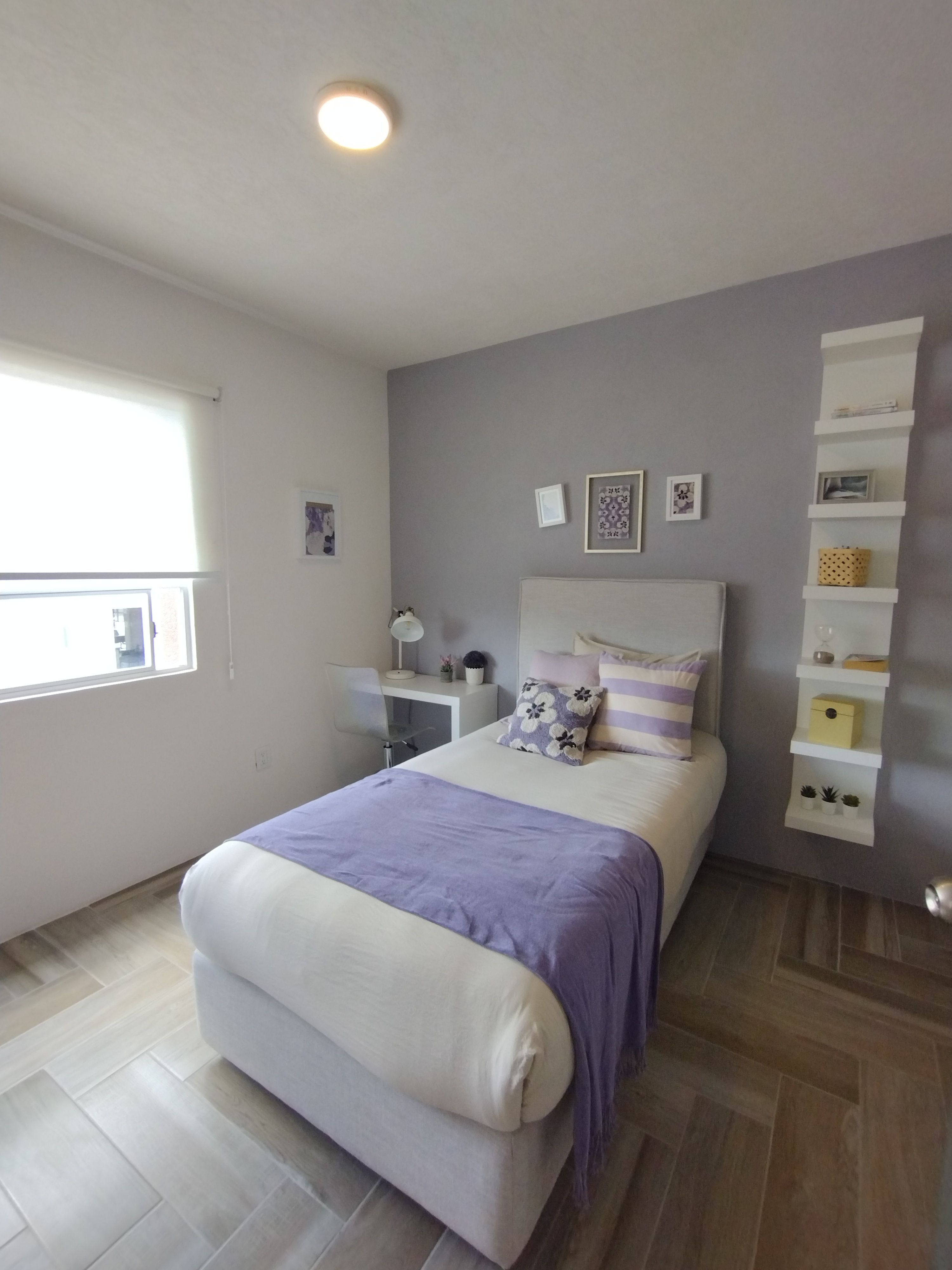 A bright and cozy minimalist bedroom featuring soft lavender accents and modern decor.