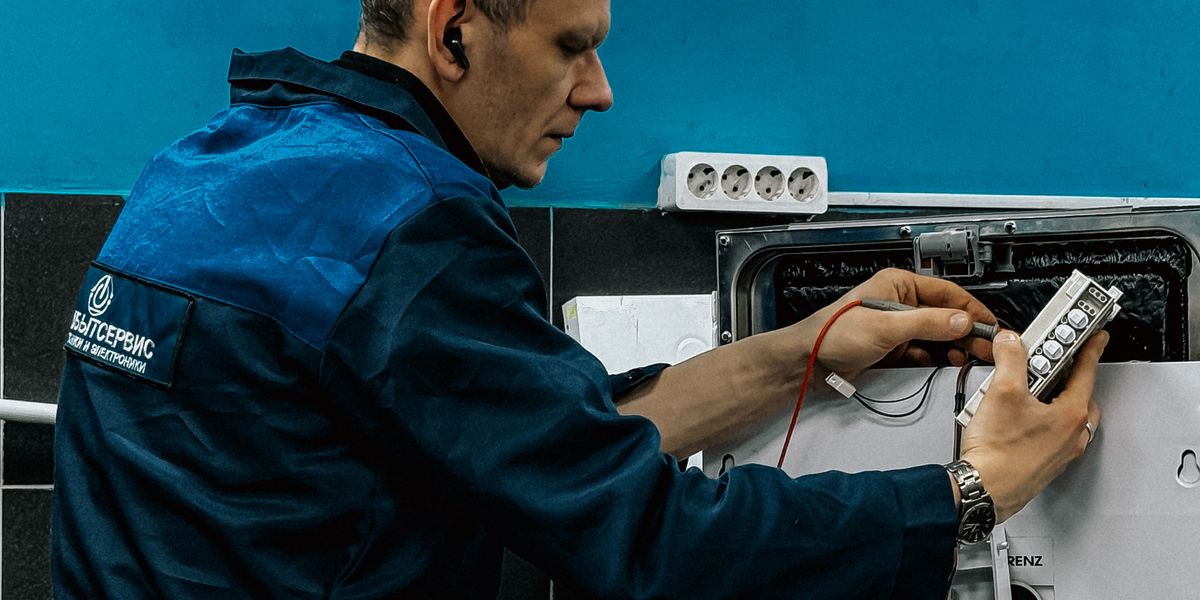 Professional AC repair technician diagnosing a home HVAC system with a multimeter