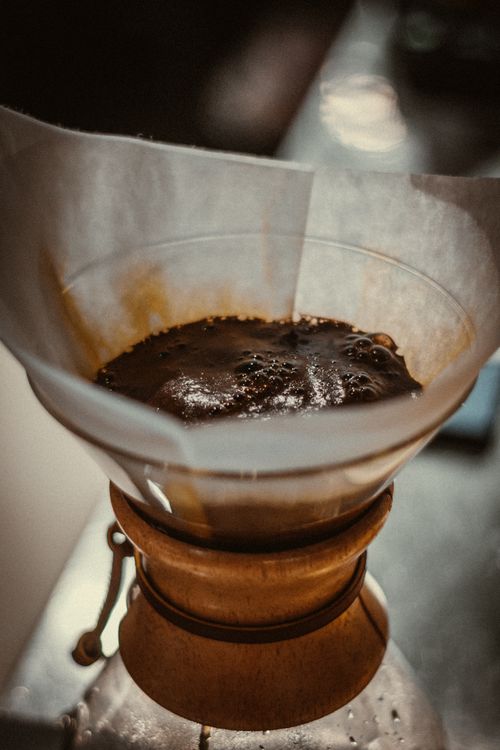 Free A close-up view of freshly brewed coffee in a Chemex filter, highlighting rich colors and textures. Stock Photo