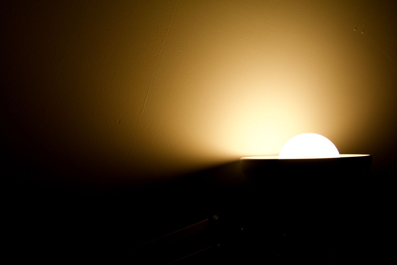 abstract photo of a glowing lamp casting light on a dark wall creating