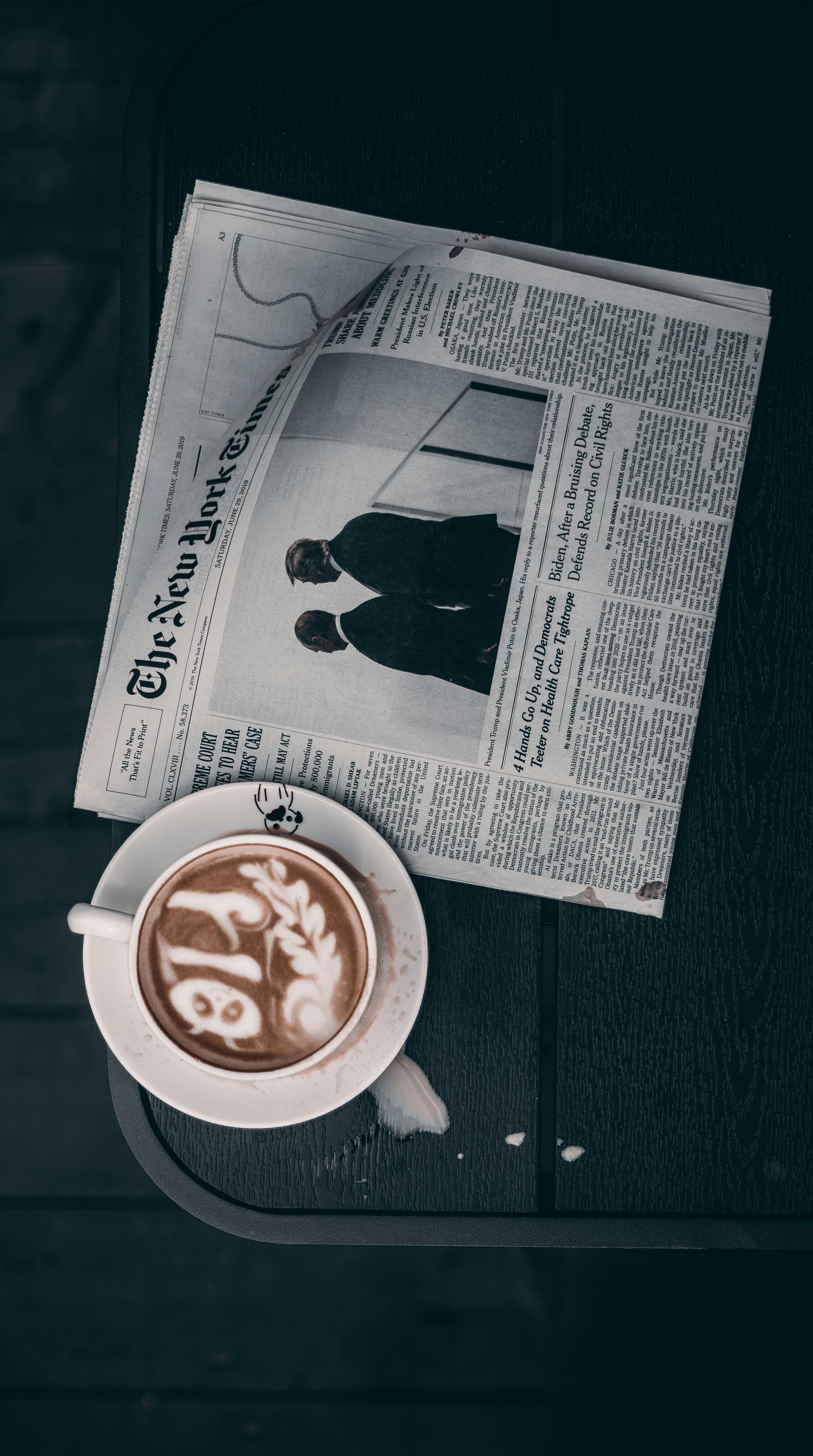 white newspaper beside teacup