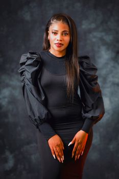 Striking portrait of a beautiful woman in elegant black attire with dramatic lighting.