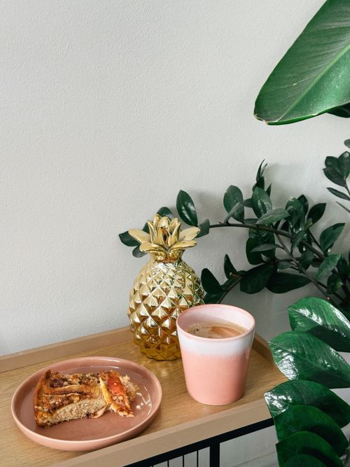 Free Elegant breakfast scene with coffee, dessert, and decorative plants. Stock Photo