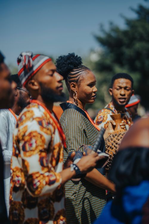 Free Group of adults wearing vibrant African clothing in a cultural celebration outdoors. Stock Photo