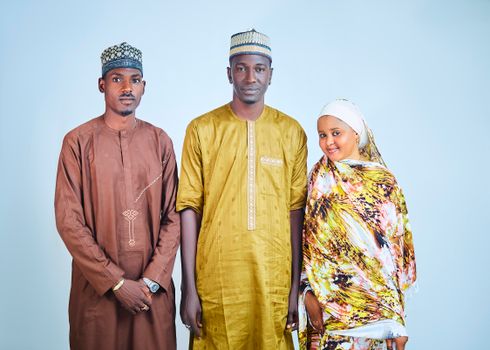 A beautiful portrait of three adults in colorful traditional African attire, smiling warmly.