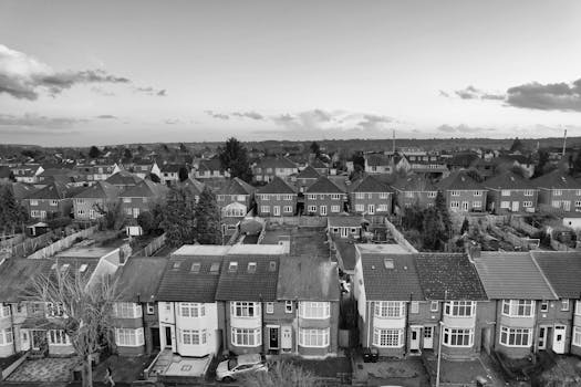 Black and white aerial shot of a UK suburban neighborhood at day, showcasing rows of houses.