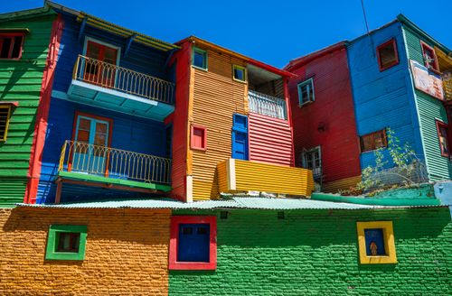 Free Vibrant, multicolored buildings in La Boca, Buenos Aires under clear blue skies. Stock Photo