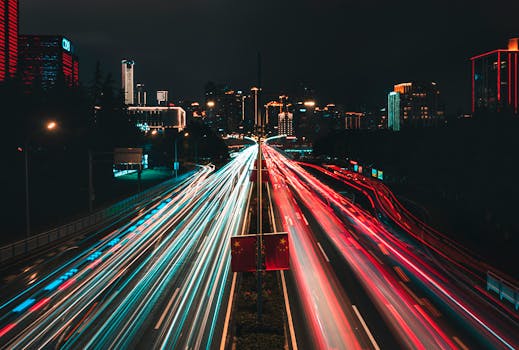 Dynamic light trails of traffic in an illuminated city at night, capturing the urban energy.