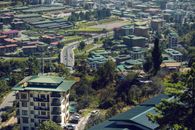 Aerial photo capturing the vibrant cityscape of Thimphu, Bhutan with green-roofed buildings.