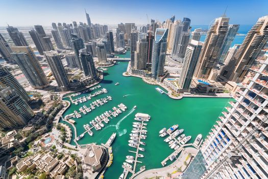 Stunning aerial view of Dubai Marina showcasing skyscrapers and yachts in clear blue waters.