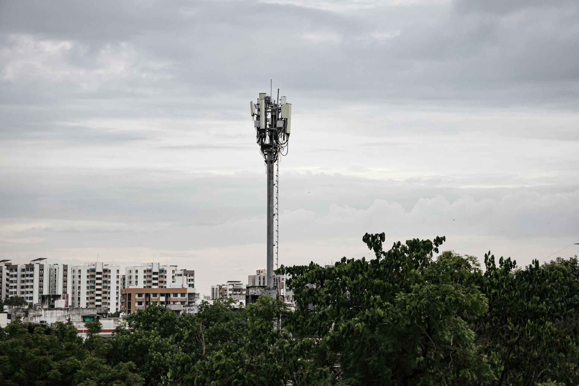 Şehir silüetinin önünde bir telekom kulesinin kapalı havada görüntüsü.