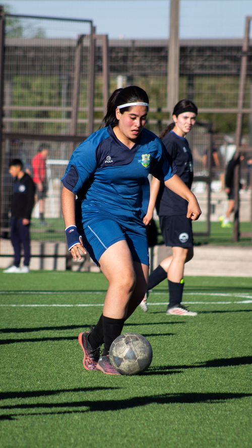 Free Two teenage girls in sports uniforms playing soccer on a sunny day. Stock Photo