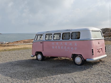 A retro pink van parked by the sea in Kinmen, Taiwan, with ocean views.