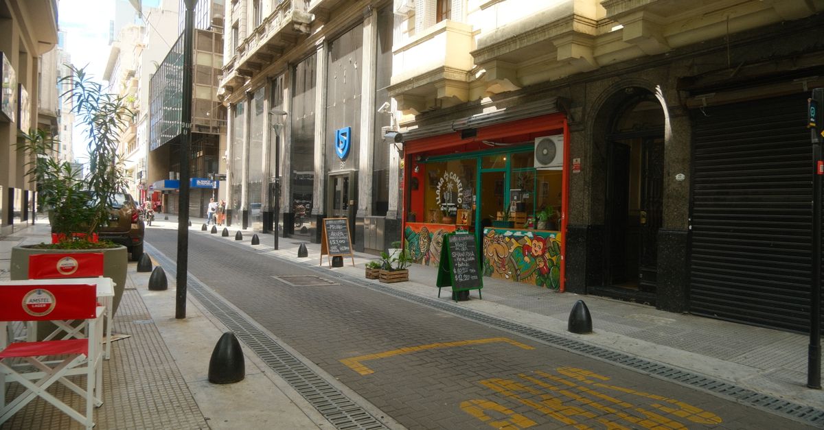 A Buenos Aires street with cafe tables out on the pavement