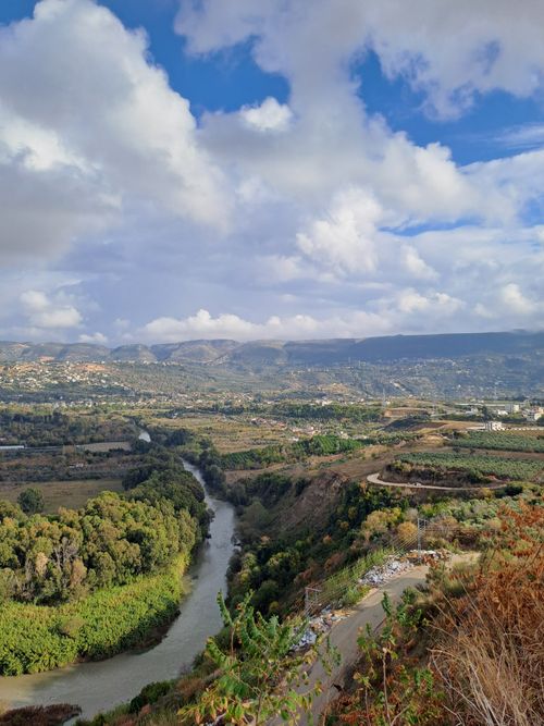 Free A breathtaking view of a verdant valley and meandering river under a vibrant sky. Stock Photo