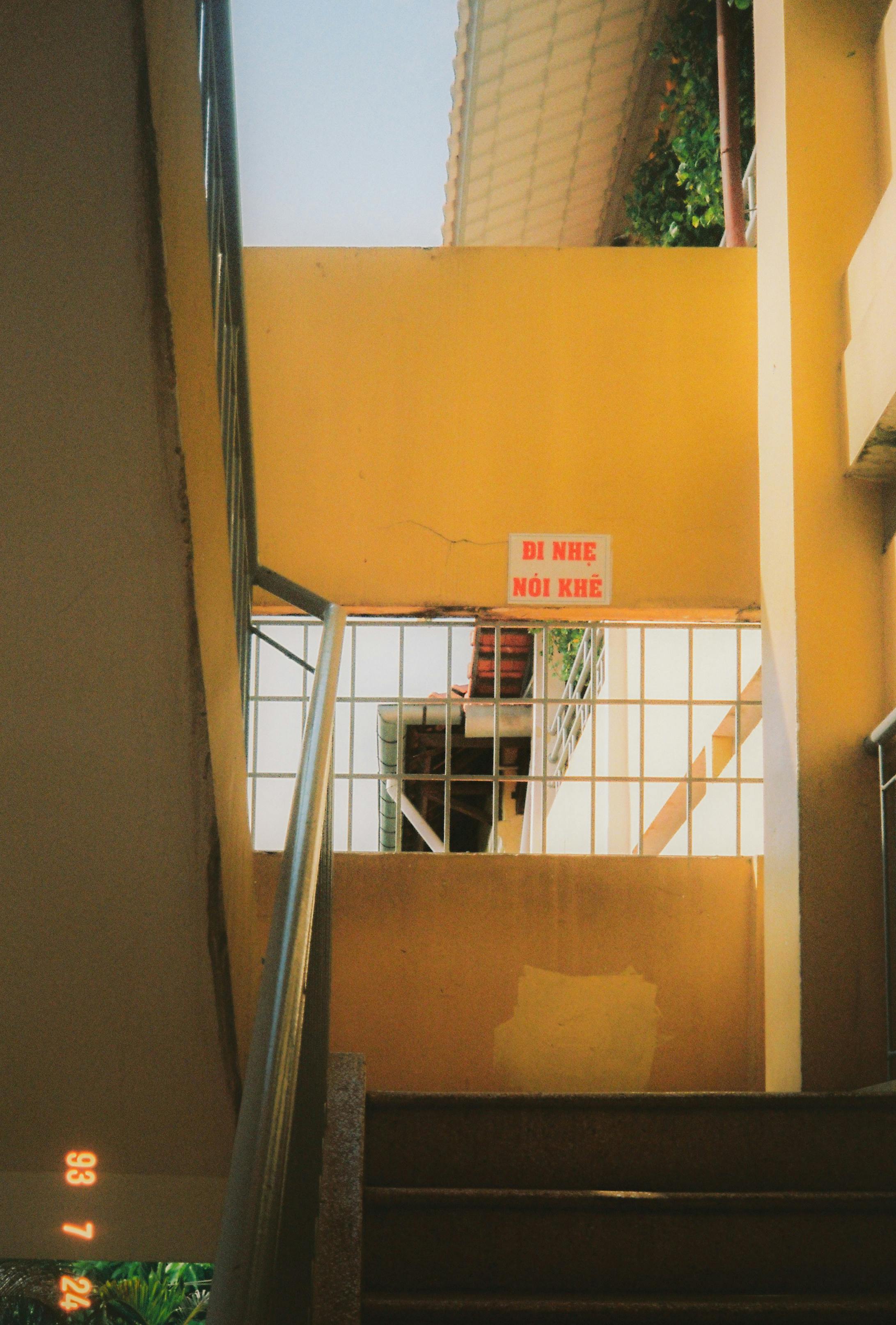 Bezpłatne Żywa klatka schodowa z jasnożółtymi ścianami i naturalnym światłem słonecznym wpadającym do środka. Zdjęcie z galerii