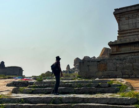 Person trekking through ancient ruins at Hampi, Karnataka, India.