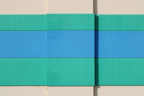 Free Abstract wall art in teal and blue hues on a beige background, creating a vibrant composition. Stock Photo